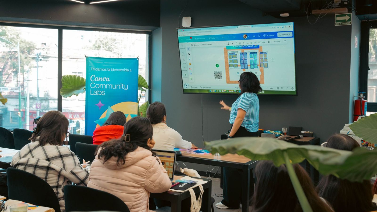 Une salle de formation avec des adultes assis face à un formateur