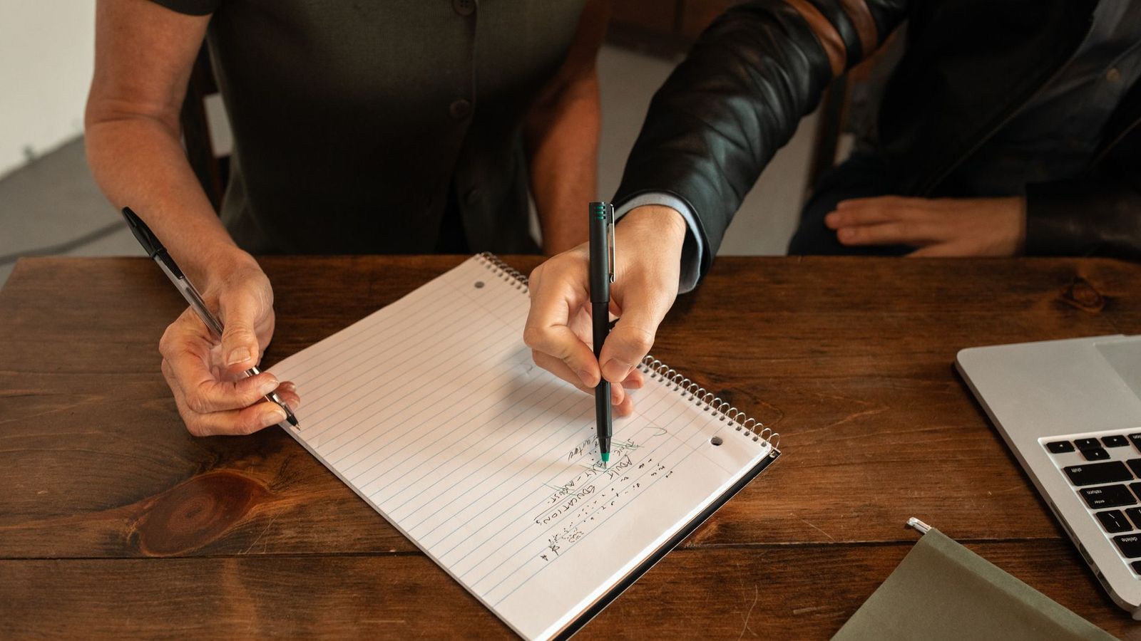 Deux personnes en discussion autour d'une table avec des notes